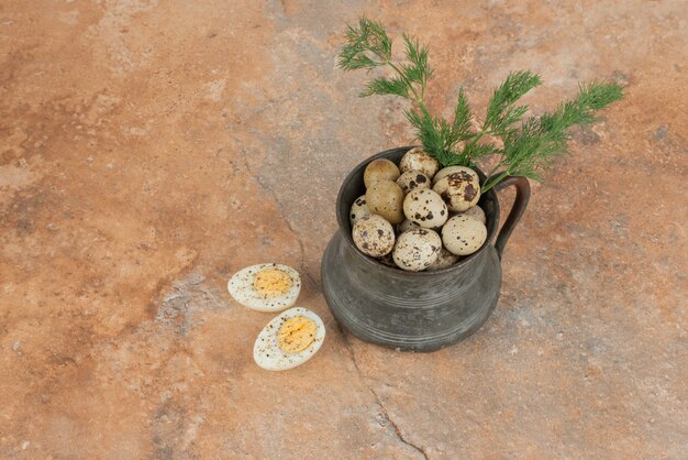 Quail eggs on the cup and boiled eggs in the marble surface