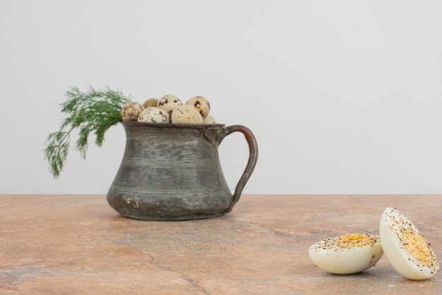 Quail eggs on the cup and boiled eggs in the marble surface