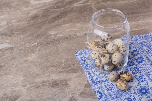 Free photo quail eggs in a glass container on the marble.