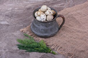 quail eggs in a metallic pot on the burlap