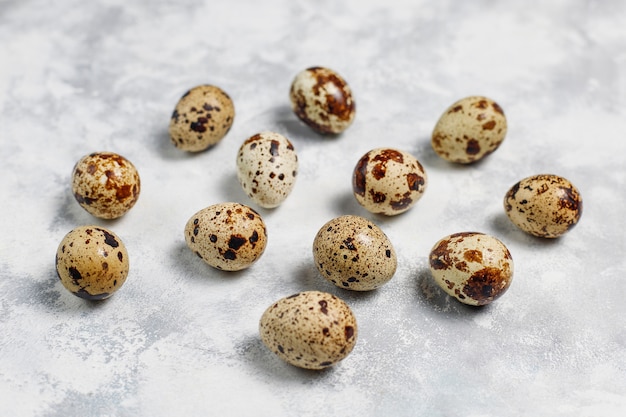 Quail eggs on a white-grey concrete  