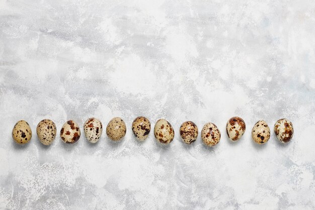 Quail eggs on a white-grey concrete  