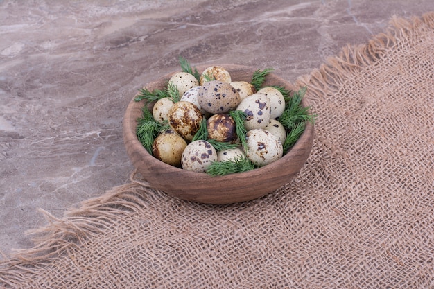 Free photo quail eggs with minced herbs in a wooden cup