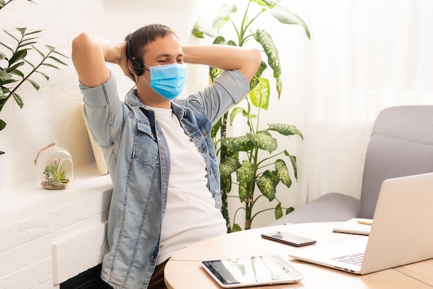 コロナウイルスのパンデミックによる検疫。家にいる。在宅勤務のビジネスマンは、保護マスクを着用してください。消毒ジェルで在宅勤務。リモートワーク、COVID-19 の流行による学習。