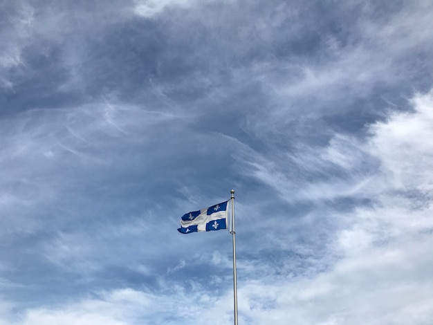 Quebec flag under the beautiful clouds in the sky