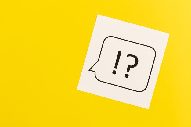 Question mark and exclamation mark on yellow background flat lay