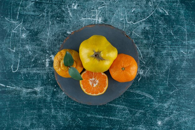 Quince and oranges on a board , on the marble background. High quality photo