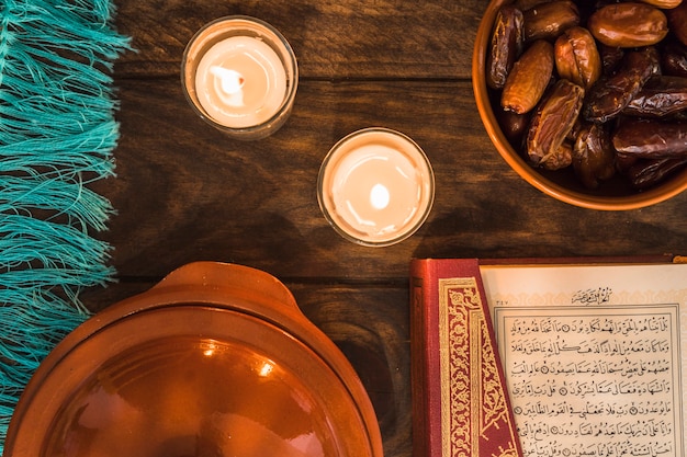 Quran and dates near burning candles