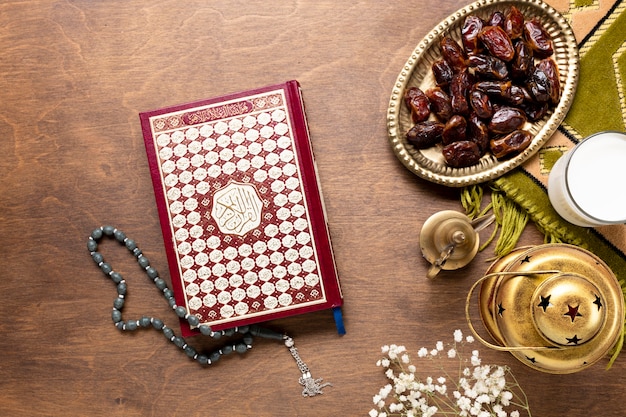 Quran and prayer beads on wooden table
