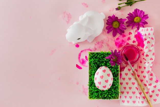 Rabbit statuette near egg and flowers