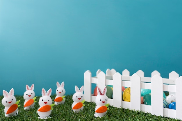 Free photo rabbits next to wooden fence for easter day