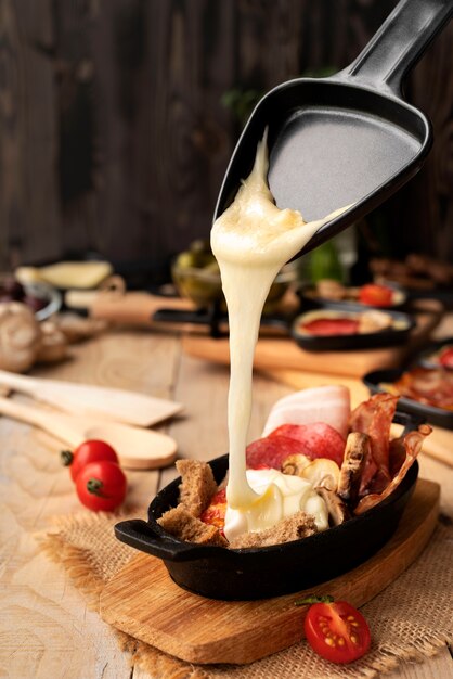 Raclette dish made with cheese and assortment of delicious food