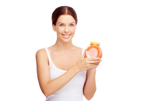Radiant woman holding a container of bath salts