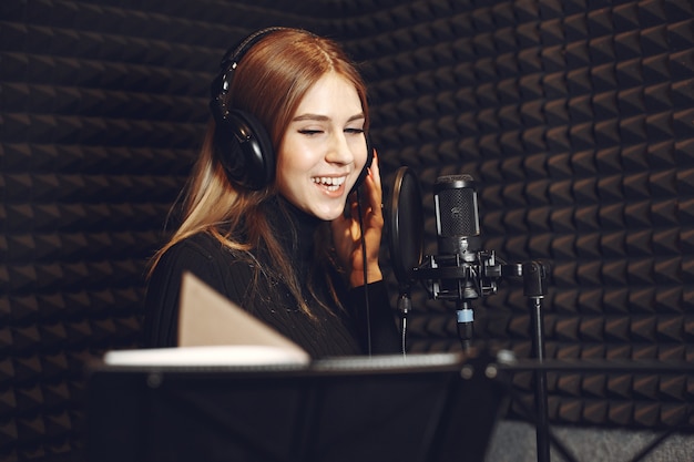 Radio host gesturing while recording podcast in radio studio.