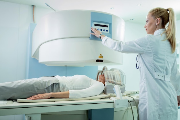 Free photo radiologist adjusting mri scanner before medical examination of a patient who is getting brain scan in the hospital