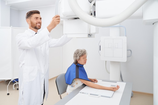 Рентгенолог регулирует ультразвуковой инструмент, готовящийся к диагностике