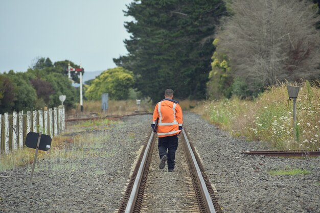 線路の間を歩いている鉄道労働者