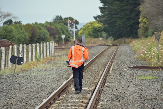 Railroad worker walking away between rail tracks