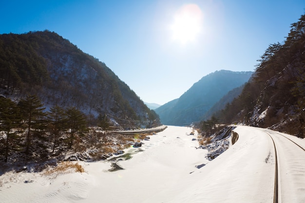 Railway line through the winter snow with sunlight