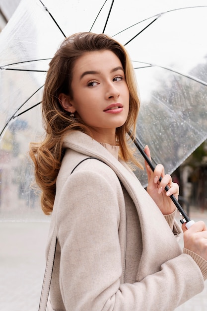 Rain portrait of young beautiful woman with umbrella