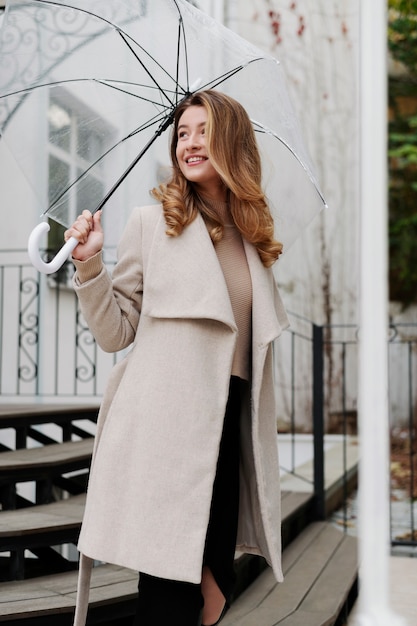 Rain portrait of young beautiful woman with umbrella