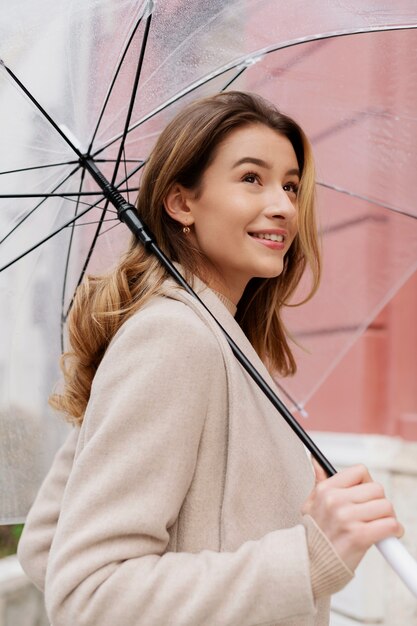 우산을 가진 젊은 아름 다운 여자의 비 초상화