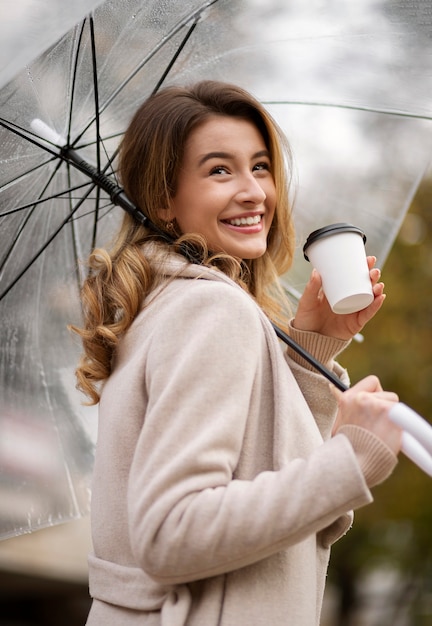 Foto gratuita ritratto di pioggia di giovane bella donna con ombrello