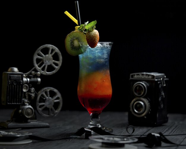 Rainbow coctail with kiwi and strawberries on the top