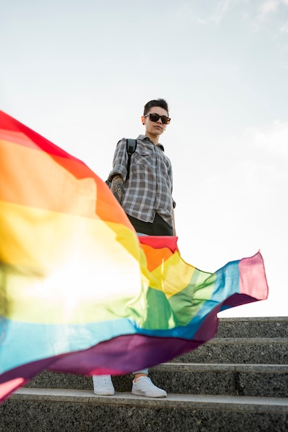 Foto gratuita bandiera arcobaleno in mano di omosessuale