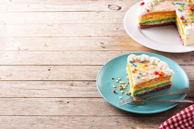 Rainbow layer cake on wooden table