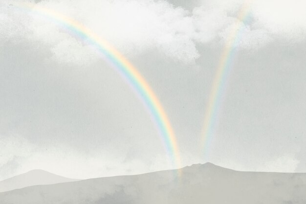 Rainbow over mountains background with clouds