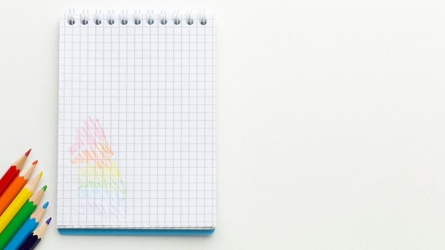 Rainbow pride flag made from pencils and notepad copy space