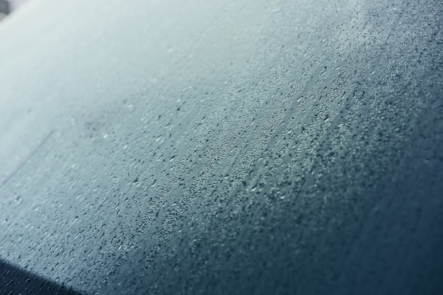 Raindrops on the hood of the car. Close-up.