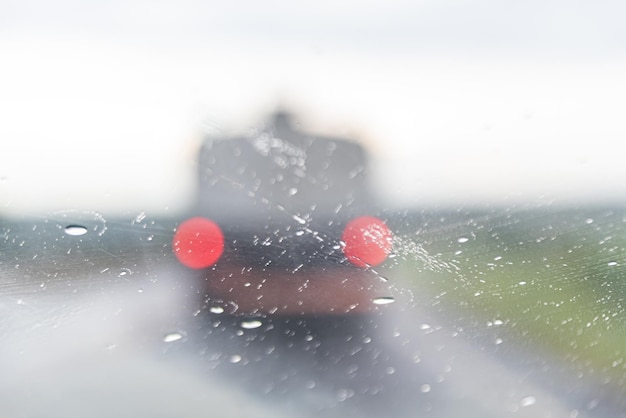 車の窓の後ろの雨の日