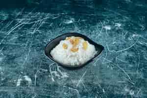 Free photo raisins on a bowl of rice pudding , on the blue background. high quality photo