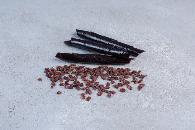 Raisins and sour cherry plum snacks on marble background.