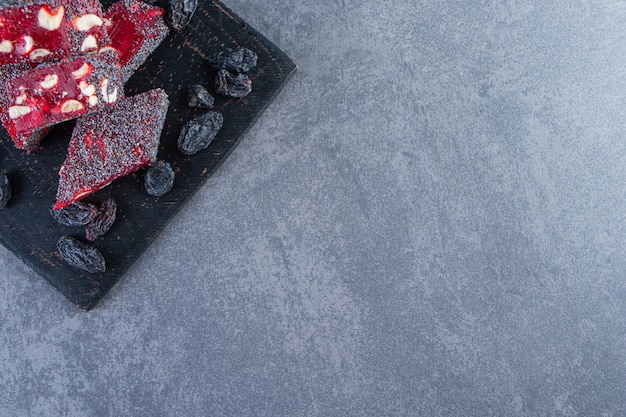 Raisins and Turkish delights in a cutting, on the marble background.