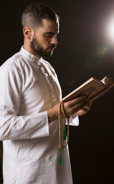 Free photo ramadam event and arabic man standing with quran and prayer beads