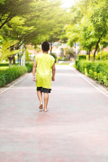庭で走る若いアジアの少年の珍しいビュー