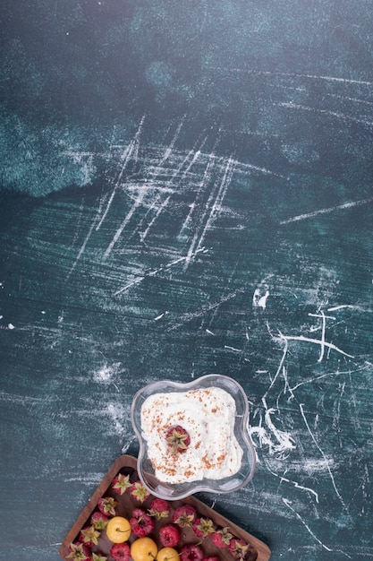 Бесплатное фото Малина и вишня на деревянном блюде со стаканом мороженого