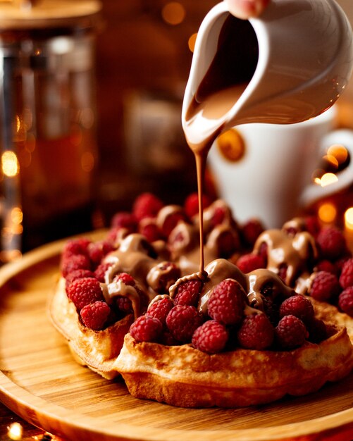 Raspberries under chocolate on the table