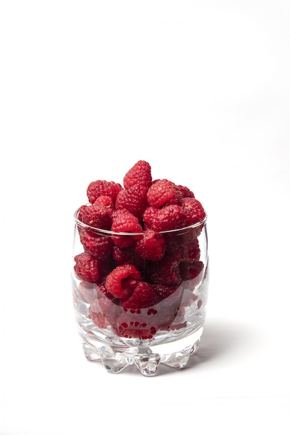 Raspberries in a glass cup isolated on white background