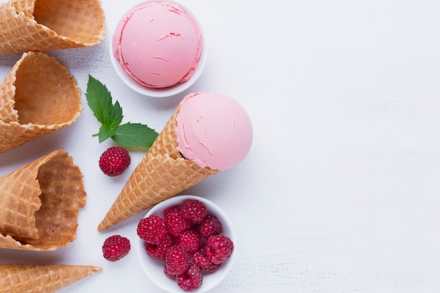 Raspberries ice cream cones on table