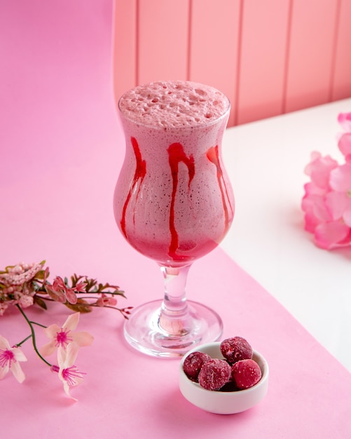 Free photo raspberry milkshake with cream milk and frozen raspberries on table