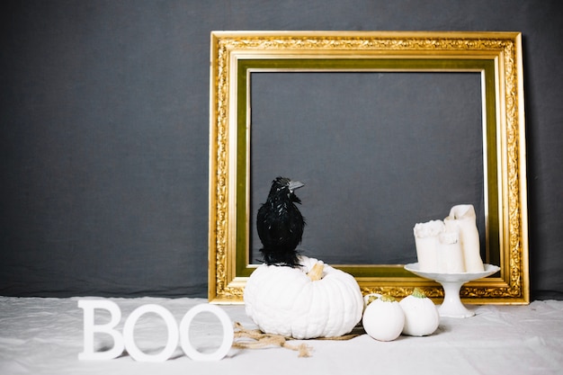 Free photo raven on pumpkin in front of frame