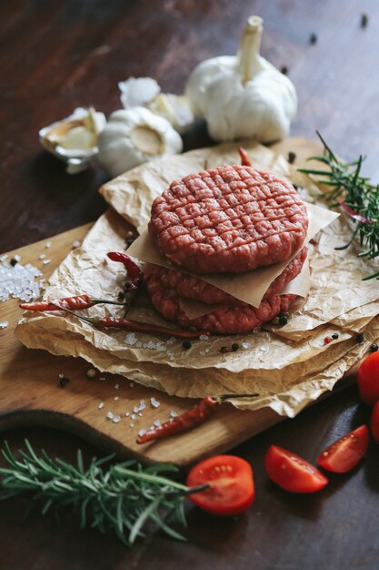 Raw beef hamburger patties with herbs and spices