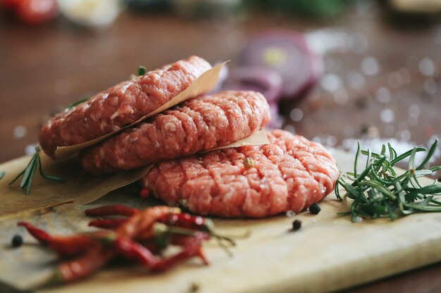 Raw beef hamburger patties with herbs and spices