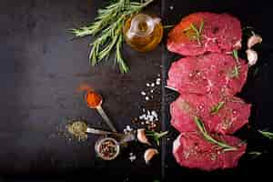 Free photo raw beef steaks with spices and rosemary. flat lay.top view