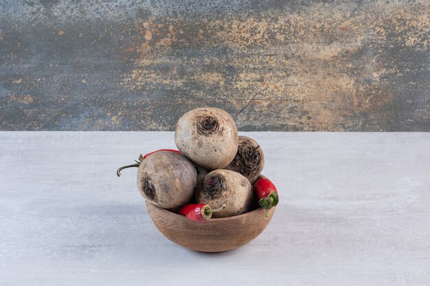 Raw beetroot and chili peppers on wooden bowl. High quality photo