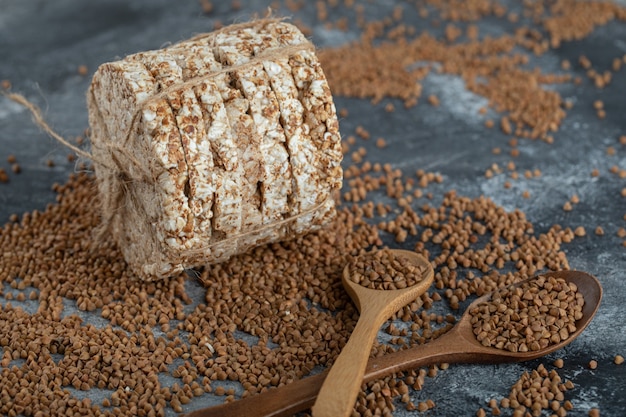 Raw buckwheat and crispbread on marble surface